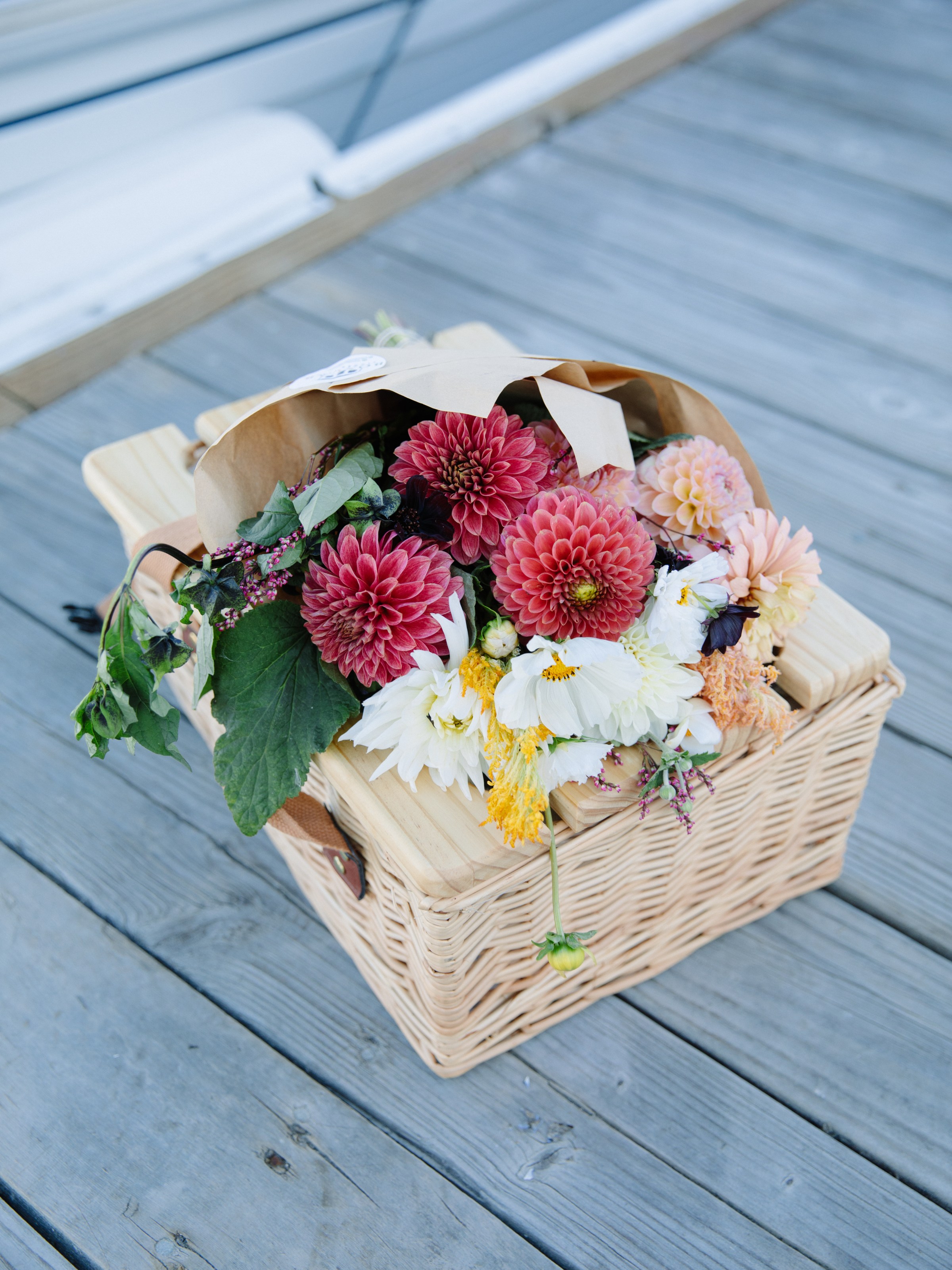 Basket of colorful flowers on wooden deck